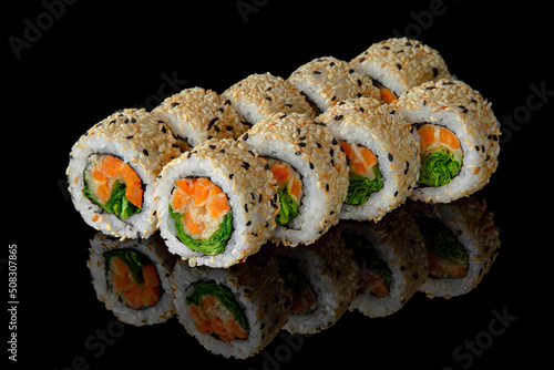 Sushi roll vegetarian with baked carrots and chuka salad on black background. Sushi menu. Japanese food.