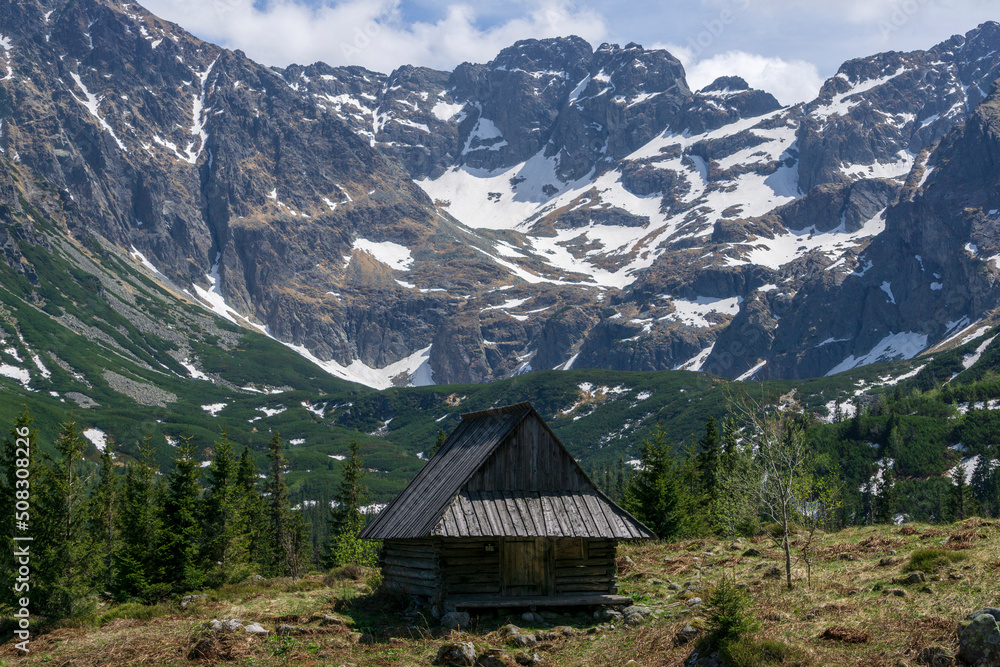 An old hut in the background of peaks. Gasienicowa Valley. Tatra Mountains.