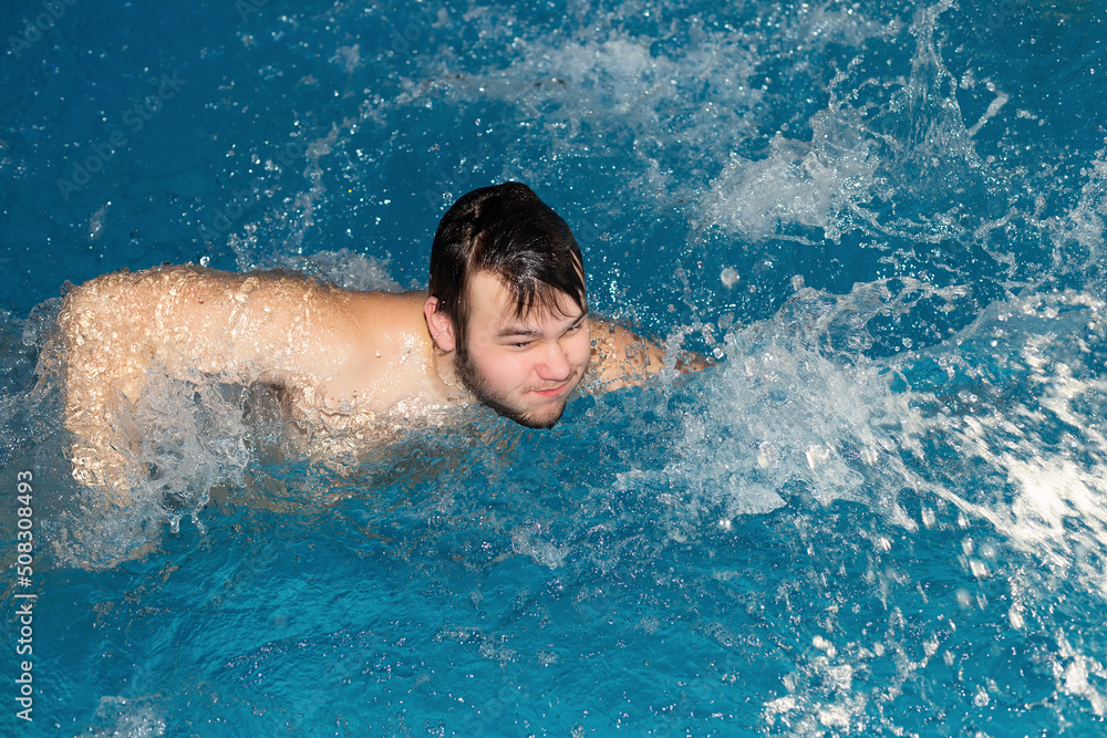 A teenager is swimming in the water. Sports and recreation. Leisure and lifestyle