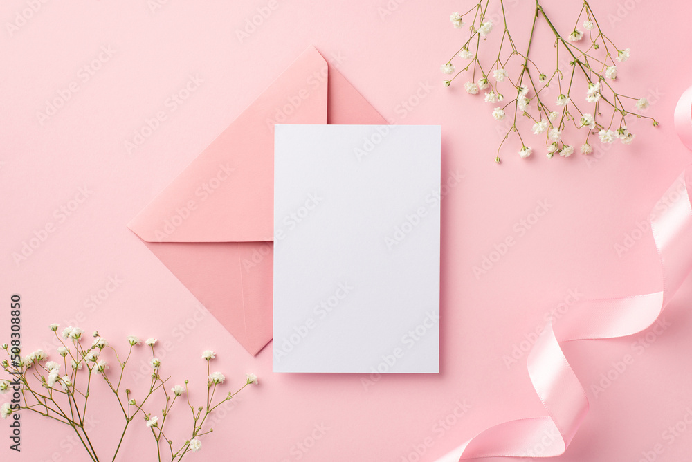 Wedding invitation concept. Top view photo of pink envelope paper card pink curly ribbon and white gypsophila flowers on isolated pastel pink background with blank space Wedding invitation concept. Top view photo of pink envelope paper card pink curly ribbon and white gypsophila flowers on isolated pastel pink background with blank space
