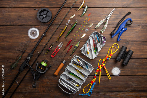 Tableau sur toile Fishing tackle - fishing spinning rod, hooks and lures on wooden background