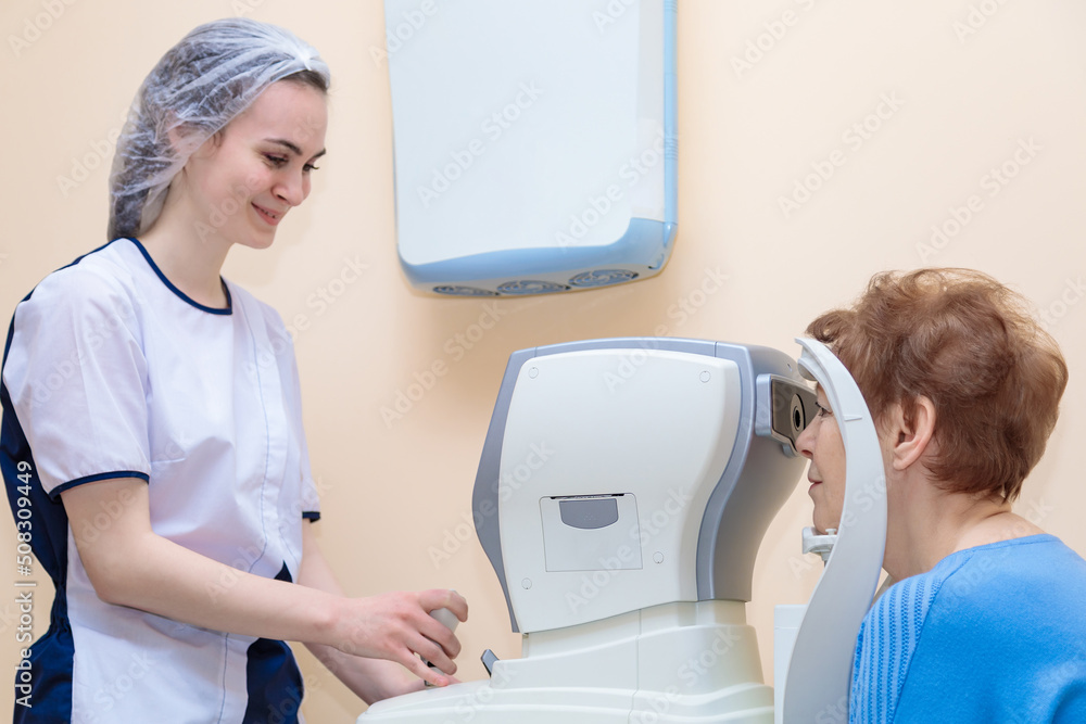 A girl optometrist examines the eyes of a patient using special modern equipment A girl optometrist examines the eyes of a patient using special modern equipment