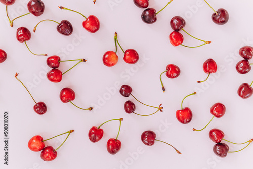 Cherry pattern. Flat lay of cherries on a pink background.Top view