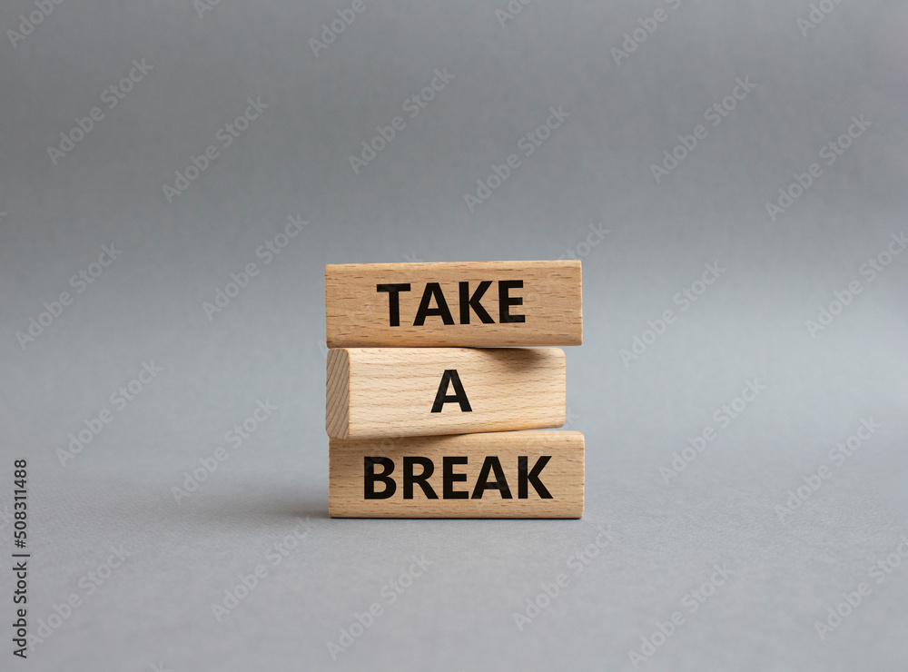 Take a break symbol. Concept words 'Take a break' on wooden blocks. Beautiful grey background. Business and Take a break concept. Copy space. Take a break symbol. Concept words 'Take a break' on wooden blocks. Beautiful grey background. Business and Take a break concept. Copy space.