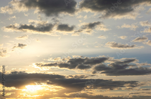 Beautiful sunset in a gray cloud on a background of blue sky and gray clouds