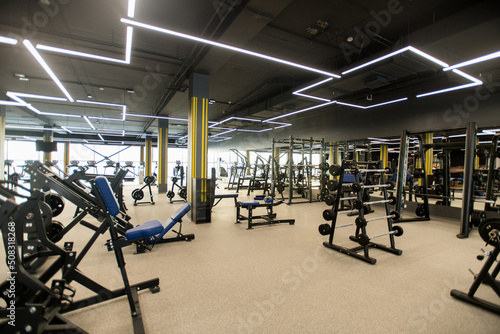 Image of beautiful modern gym with different sports equipments and barbells for weight training