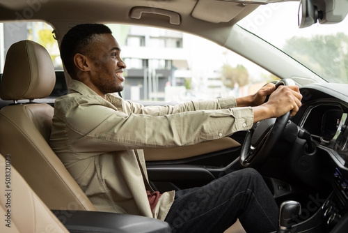 Side portrait of happy african american man driving car © Home-stock