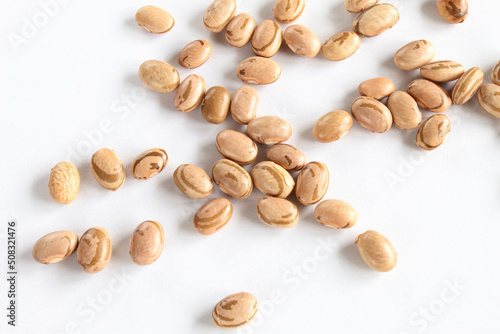 Carioca beans scattered on white surface, brazilian beans.