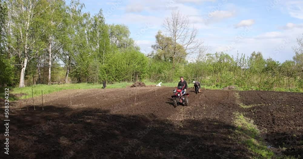 People in the field in the garden with a tillerblock to plant potatoes. People in the field in the garden with a tillerblock to plant potatoes.