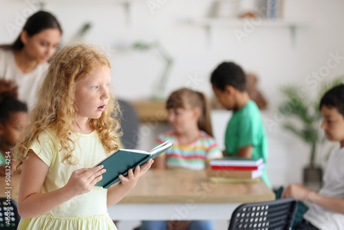 Little redhead girl reading...