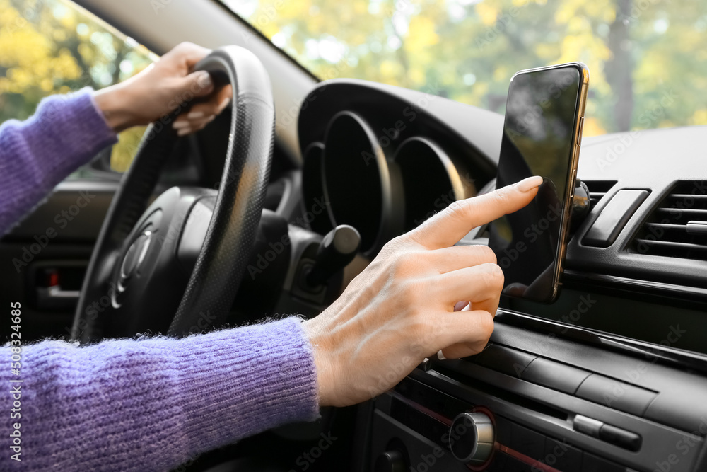 Female driver using smartphone for navigation, closeup