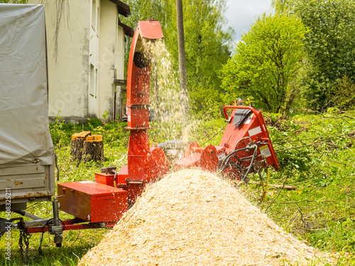 Mobile wood and branch shredder in the city park. Agricultural machinery, wood chipping machine