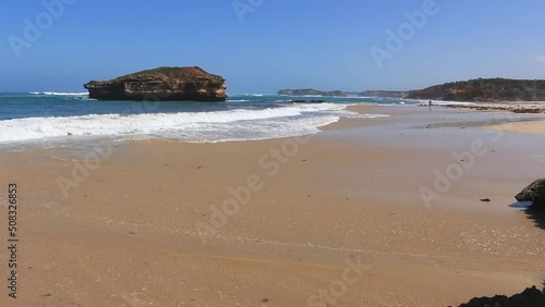 Twelve apostles beach on a sunny day at sunset surrounded by waves and cliffs in the nature - Great ocean road, Victoria, Australia.