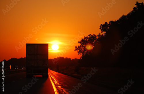 In the Midwest, USA. A semi truck on the highway as the sun is setting. photo