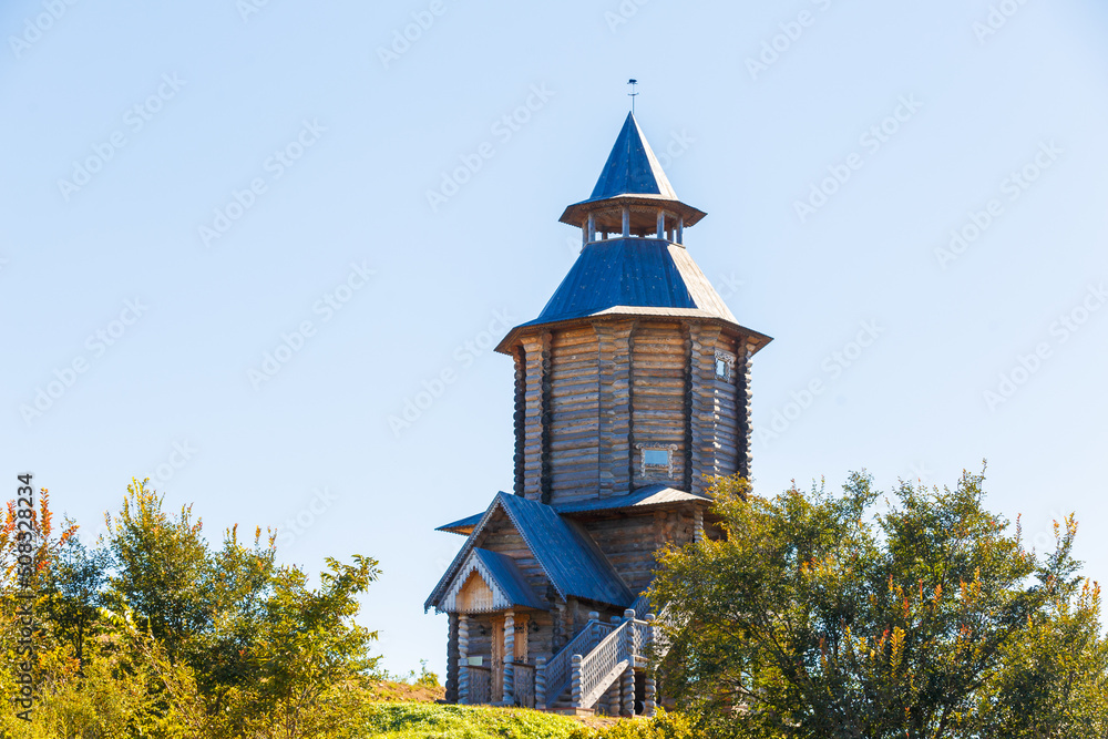Old Slavic tower of the Sun in the old village. Wooden religious pagan tower for prayers. Russian village.