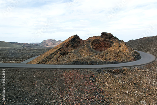 Landscape of a vast lava field. The road was made with solidified lava. Lanzarote, Canary Islands, Spain