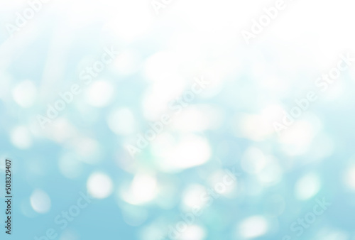 Defocused Bright abstract winter background with shimmering sunspots in white and blue. Bokeh. Holiday festive concept. Copy space for text. Merry Christmas and Happy New Year
