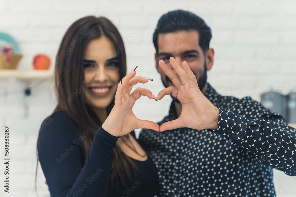 A lovely cute couple making a heart gesture to the camera. High quality photo A lovely cute couple making a heart gesture to the camera. High quality photo