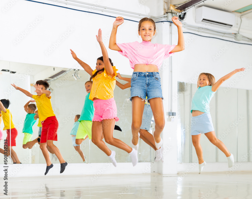 Kids jumping together while dancing on their group training.