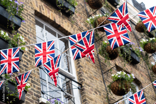 British Union Jack flag triangular hanging in preparation for a street party. Festive decorations of Union Jack bunting. Selective focus  photo