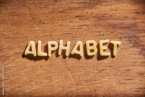 Word Alphabet formed with pasta letters on a wooden background.