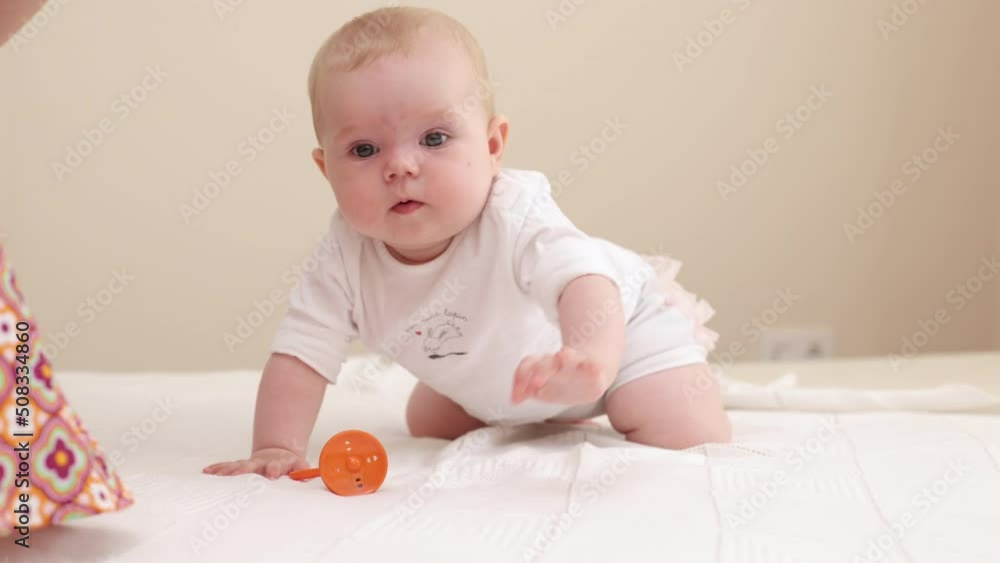 Curious adorable little baby girl crawling and learning for the first time on white home background Curious adorable little baby girl crawling and learning for the first time on white home background