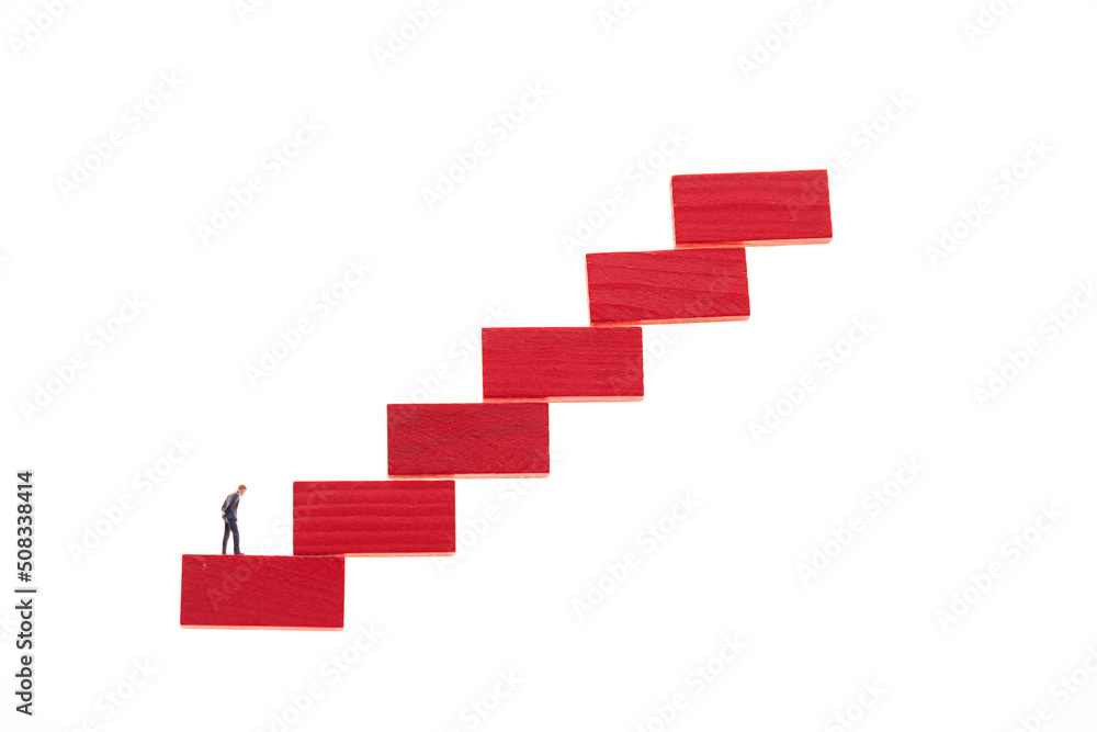 Career ladder concept.Career growth concept. Figurine of a businessman on a red ladder isolated on a white background