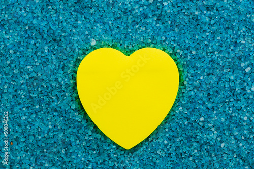 Paper sticker in the shape of a heart on the background of sea aromatic bath salts. The concept of romantic enjoyment photo