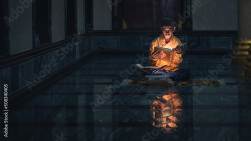 Fotografie, Obraz muslim man studying and reading Islam holy quran book in mosque