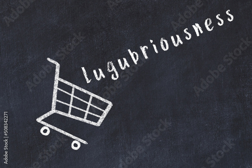Chalk drawing of shopping cart and word lugubriousness on black chalboard. Concept of globalization and mass consuming