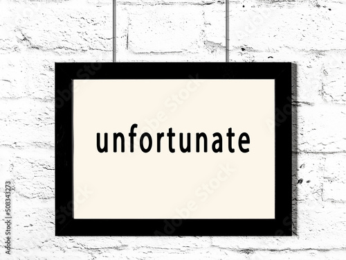 Valokuva Black frame hanging on white brick wall with inscription unfortunate
