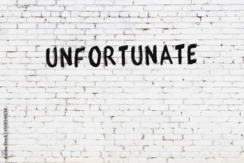 White wall with black paint inscription unfortunate on it