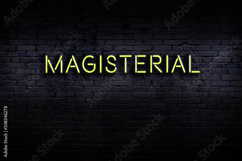 Bilde på lerret Neon sign. Word magisterial against brick wall. Night view