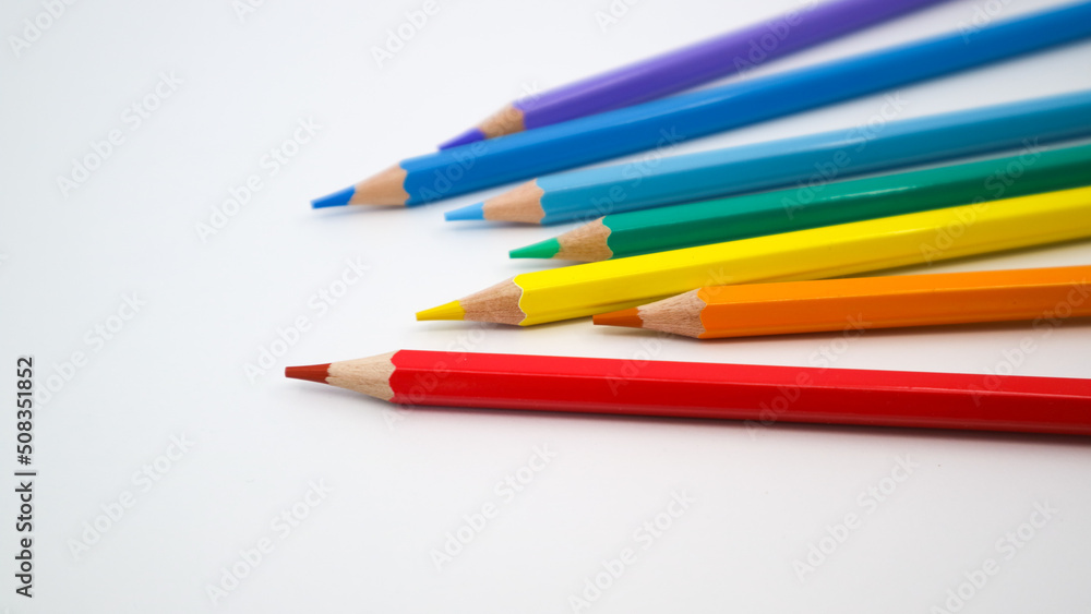 Many different colored pencils on white background