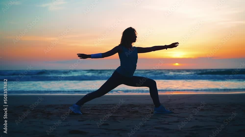 Silhouette Woman practice yoga warrior pose to meditation with summer vacation beach happiness and relaxation. Calm female exercise with yoga meditate ocean beach with sunset. Mental health. Silhouette Woman practice yoga warrior pose to meditation with summer vacation beach happiness and relaxation. Calm female exercise with yoga meditate ocean beach with sunset. Mental health.