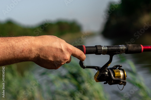 Closeup of mans hand on fishing rod and reel