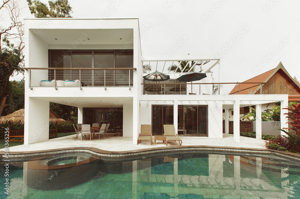 White two-story luxury villa with large outdoor pool