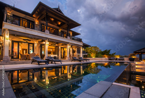 Fotografiet Luxury Rich large two-storey villa with open-air pool, interior evening photo