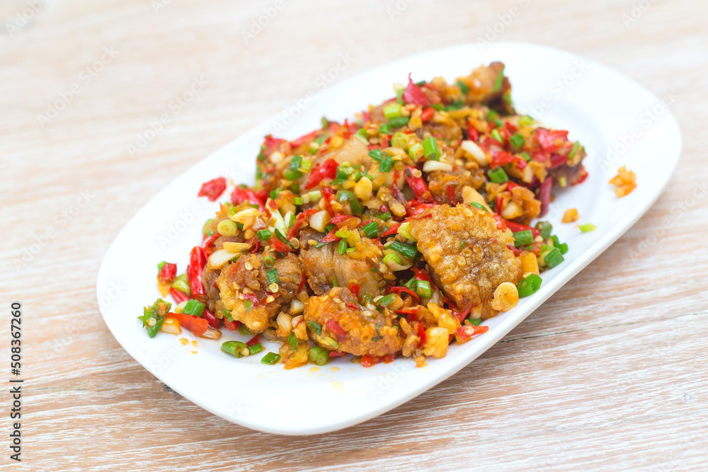 Stir Fried crispy pork with salt, fresh red chili, minced garlic and spring onion. It has spicy flavor in a delicious Thai food style. Stir Fried crispy pork with salt, fresh red chili, minced garlic and spring onion. It has spicy flavor in a delicious Thai food style.