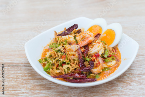 Thai wing bean salad with fresh coconut milk shrimp served with boiled eggs is a delicious Thai food style while put on a wooden table.