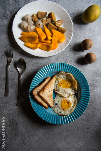 Bread slices and egg poach in a blue bowl. Top view, selective focus.