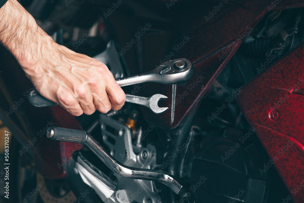 mechanic fixing a motorcycle in the garage mechanic fixing a motorcycle in the garage