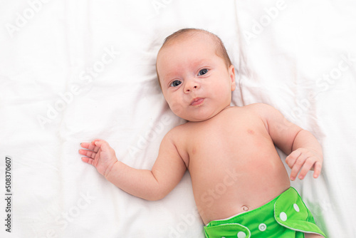 Reusable diaper on the baby copy space . An article about reusable diapers. Saving on diapers. Concern for the environment. Eco-products. Breathable diapers with buttons. High quality photo