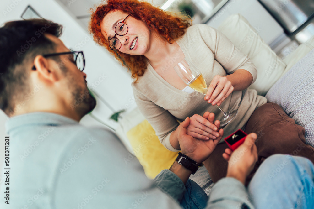 Smiling man holding red box with marriage engagement ring and make proposal to happy girlfriend. Smiling man holding red box with marriage engagement ring and make proposal to happy girlfriend.