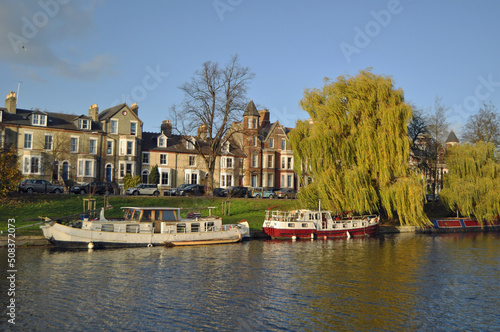 A picturesque view of boats on the river Cam in Cambridge in the Autumn with trees U.k.
