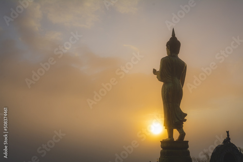Golden Buddha statue in the morning at Wat Phra That Khao Noi, or Phrathat Khao Noi temple, is the top attraction with a fantastic view of Nan province, Thailand