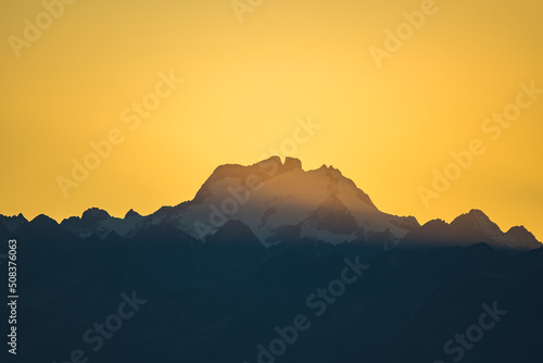 Sunset behind the peak of Oberalpstock in the swiss mountain region of Surselva in the canton Graubünden photo