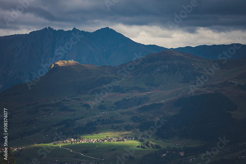 The village of Obersaxen and the mountain peak of Piz Mundaun are highlighted in the last light of the evening