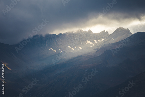 Sun shines through a mountain ridge in the swiss alps © Nicolas Buechi