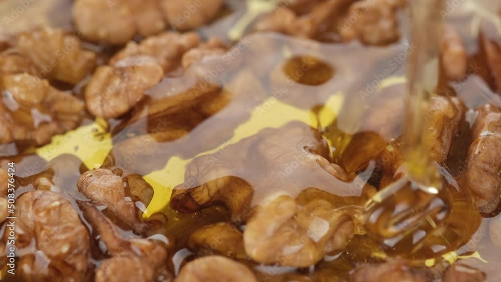 Nuts and honey. Pouring honey on walnuts, close up. Sweet honey walnuts. Healthy food concept Nuts and honey. Pouring honey on walnuts, close up. Sweet honey walnuts. Healthy food concept